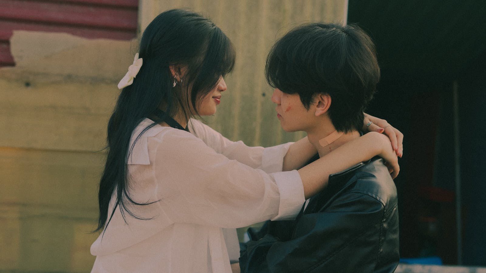 A young couple sharing a tender moment outdoors, embracing lovingly.